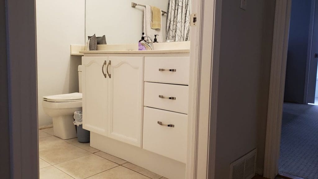 Trendy white painted bathroom vanity with silver handles