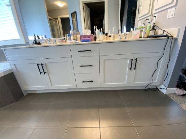 Modern white painted master bath vanity with black handles