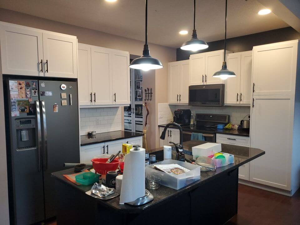 White surround cabinetry with navy accent island painted cabinets